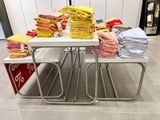 une table sur laquelle sont posées de nombreuses chemises pliées