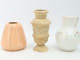 three vases sitting next to each other on a white surface