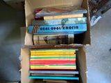 de nombreux livres dans une boîte en carton posée sur le sol