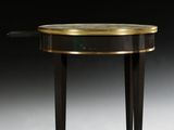 une console noire et dorée avec un plateau en verre