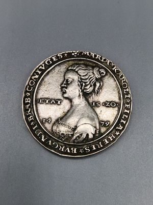 gros plan d'une pièce de monnaie sur laquelle figure un visage de femme