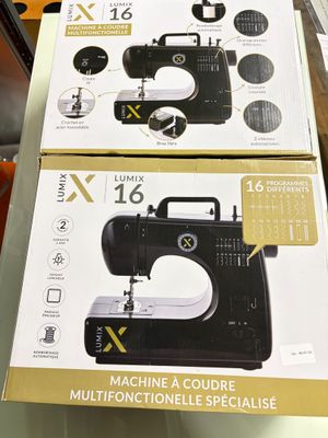 deux cartons contenant des machines à coudre posés sur une table dans un magasin