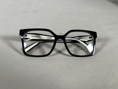 une paire de lunettes noires posée sur une surface blanche