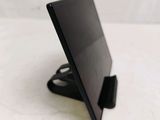 a black tablet computer sitting on a stand on a table