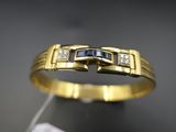 un gros plan d'une bague en or jaune sertie de diamants bleus et blancs