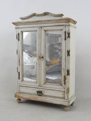 une petite armoire blanche surmontée d'un miroir