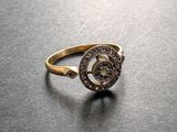 un gros plan d'une bague en or sertie de diamants posée sur une table