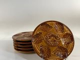 four brown plates sitting on top of each other on a table