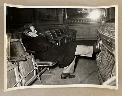 photographie en noir et blanc d'un homme assis sur une chaise dans un théâtre