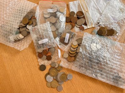 beaucoup de pièces de monnaie dans des sachets posés sur une table