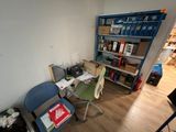 un bureau avec une chaise et une étagère dans le coin