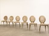 four chairs are lined up in a row in a white room