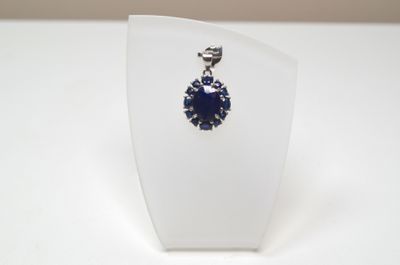 Un pendentif en argent serti au centre d'un saphir facetté o…