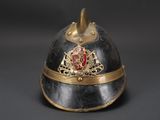 a black helmet with a gold and red emblem on it