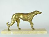 statue of a golden dog on a marble base on a white background