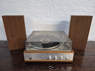a close up of a record player and speakers on a wooden table