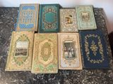 several books are lined up on a table with a wall in the background