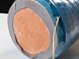 a close up of a blue vase on a white table