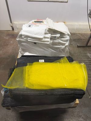 des bagages jaunes et noirs posés sur une palette dans un entrepôt