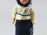 a small doll that is wearing a blue hat and dress