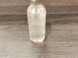 une petite bouteille remplie de liquide posée sur une table en bois
