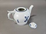 a white tea pot with blue flowers on it and a lid