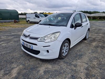 une petite voiture blanche garée dans un parking