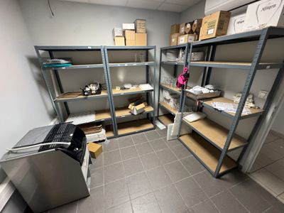 une pièce avec de nombreuses étagères et des cartons posés sur ces étagères