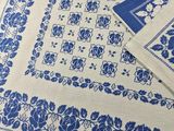 a close up of a table cloth with blue flowers on it