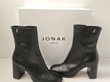 un gros plan sur une paire de bottines en cuir noir