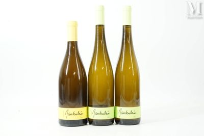 trois bouteilles de vin posées les unes à côté des autres sur une surface blanche