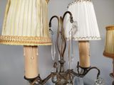 a chandelier with three lamps and a lamp shade on it