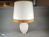 une lampe blanche avec une bordure dorée et un abat-jour blanc