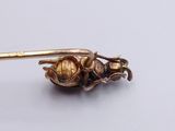 a gold bug that is sitting on top of a spoon