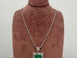 a necklace with a green stone on a mannequin neck