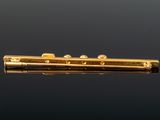 a close up of a gold plated flute on a black background