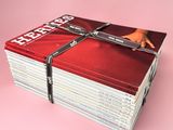 plusieurs magazines empilés les uns sur les autres sur une surface rose