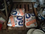 several bags of rice sitting on top of a wooden pallet