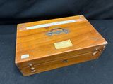an old wooden box sitting on a black surface with a tag on it