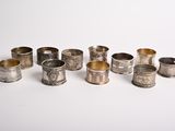 Plusieurs serviettes et tasses en argent sont alignées sur une surface blanche