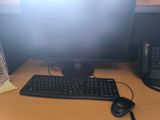 a computer monitor and keyboard on a desk with a water bottle