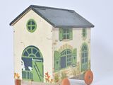 a small wooden toy house with a horse and carriage