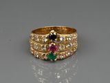 gros plan d'une bague en or avec trois pierres de couleurs différentes
