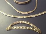 two pieces of jewelry that are on a table