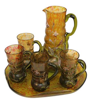 a tray with a pitcher, cups, and a tray with glasses on it