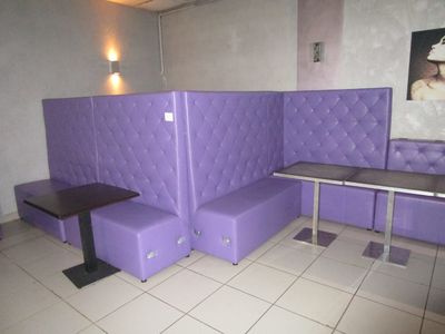 une cabine violette avec une table noire et deux bancs violets