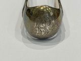a silver spoon with a metal handle on a white surface