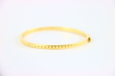un bracelet rigide en or orné de petits points