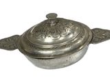 an antique silver plate with a lid on a white background
