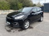 La voiture noire est garée sur le parking.